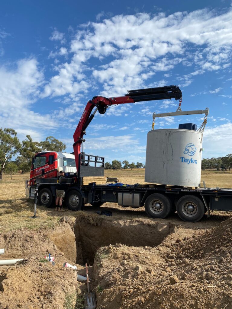 All Purpose Plumbing team placing a wastewater storage tank at a job site