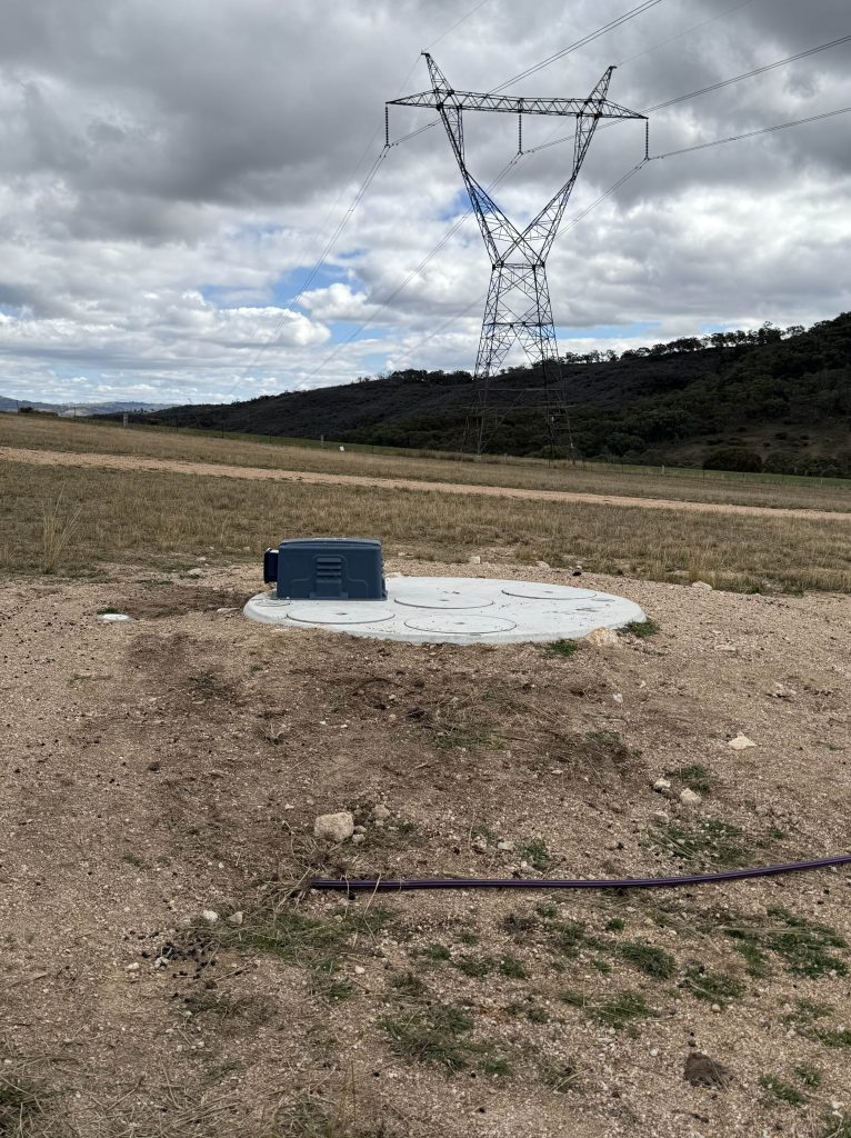 Installed septic tank with only access risers and inspection lids visible above ground